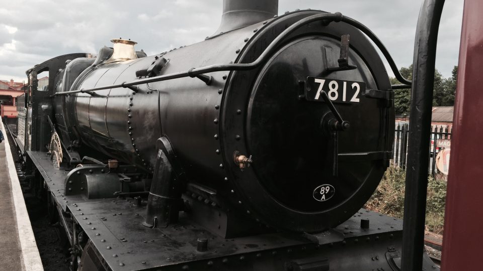 A black steam engine on the Severn valley railway, engine number 7812 on its nose.
