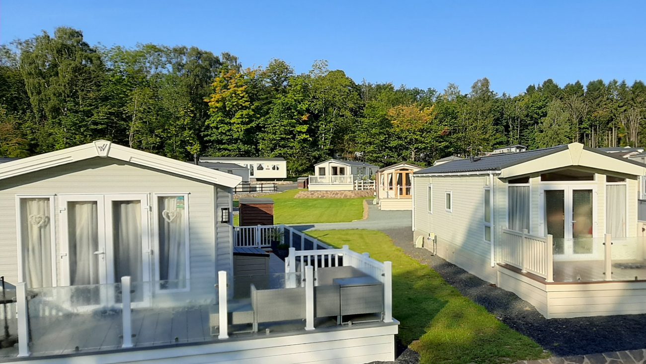 Blue sky, bright summer's day with 5 Static caravans, well spaced on Lodge Coppice Holiday Park