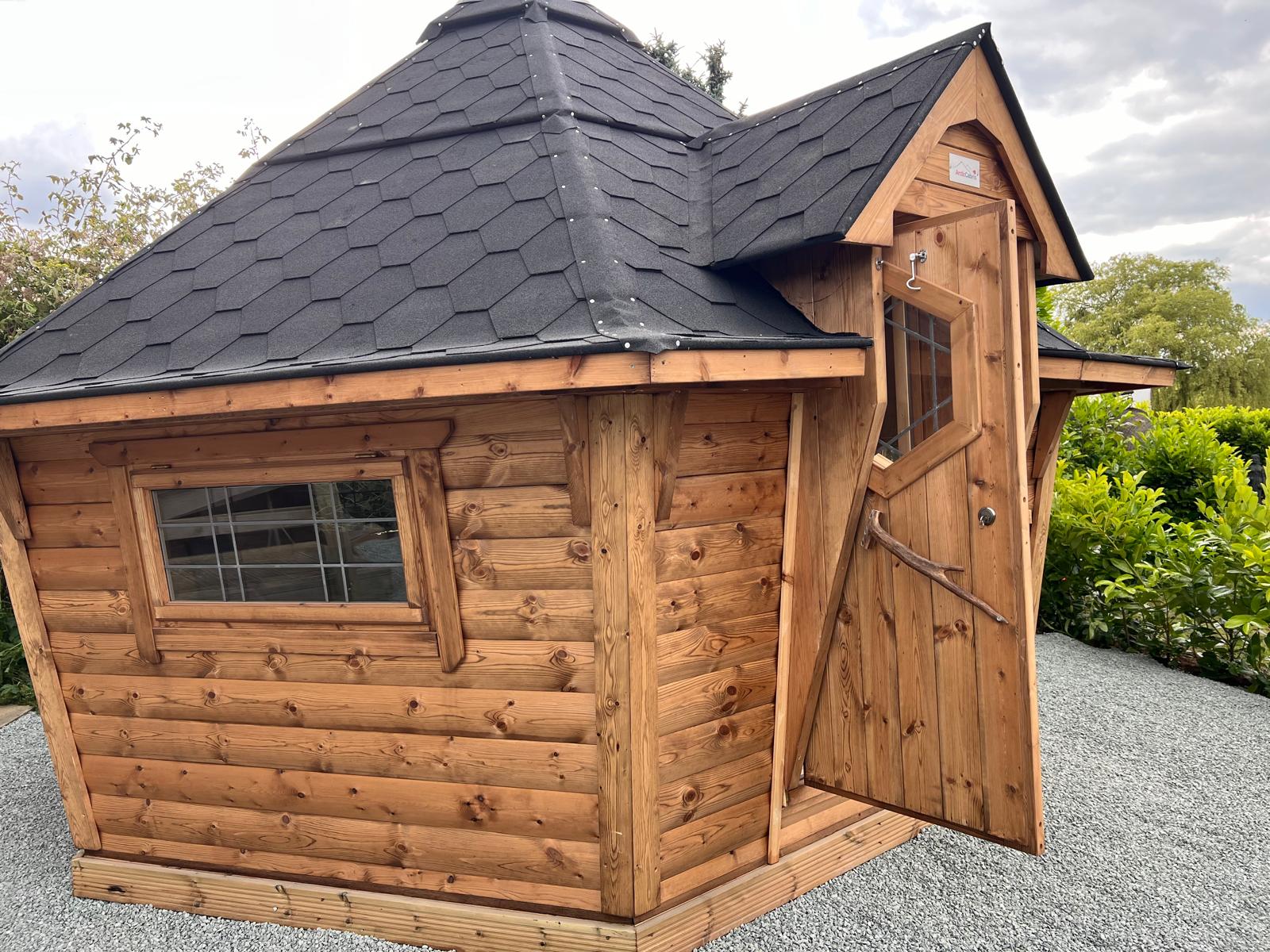 The new party hut with sloping grey tiled roof and wooden boards