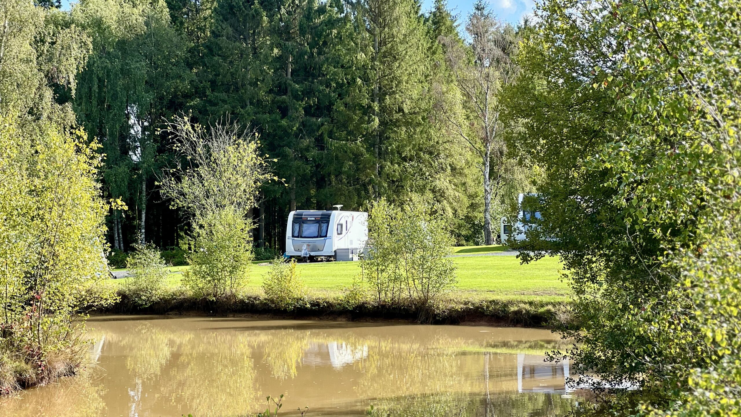 Touring caravan near pool at lodge coppice