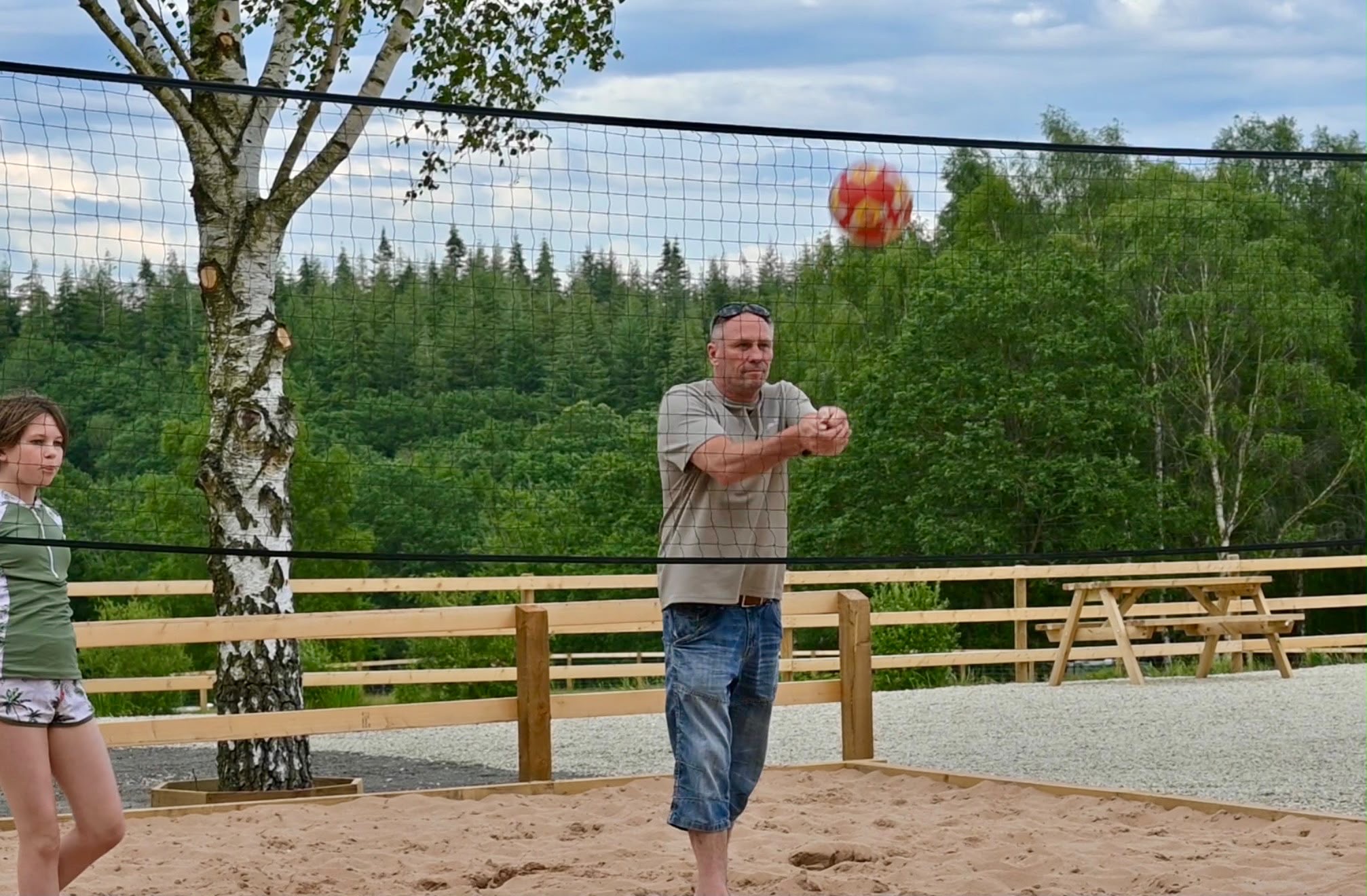 Man playing volleyball, hitting ball over net